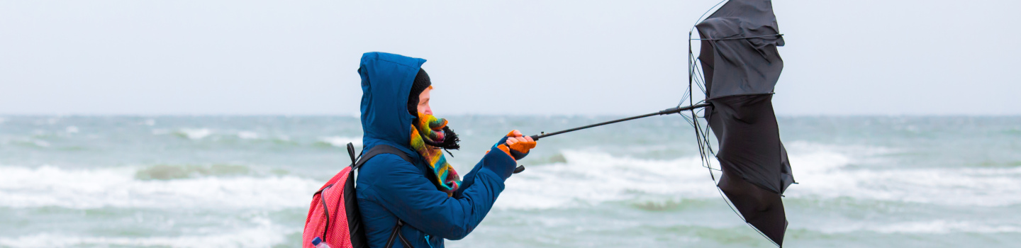 vrouw op het strand tijdens storm en wind