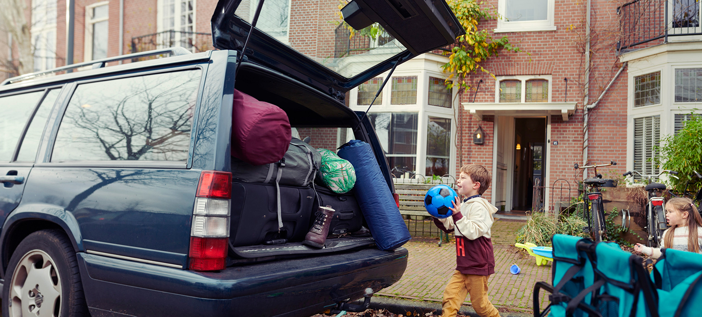 Kinderen pakken auto in voor vakantie