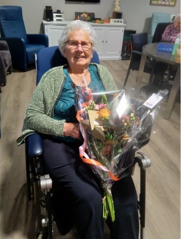 mevrouw nikkels met een bos bloemen